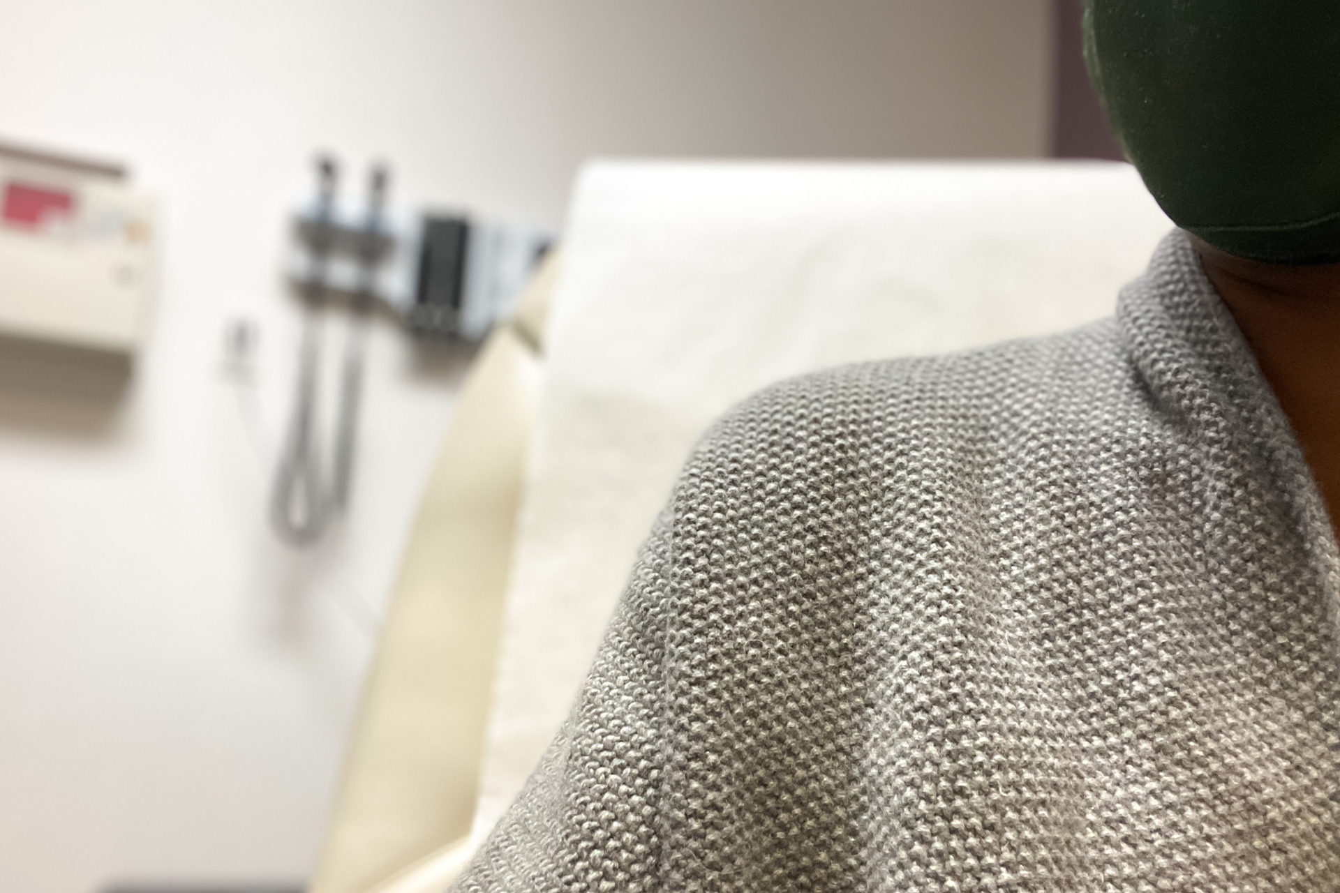 a woman sitting on patient examination chair in medical office