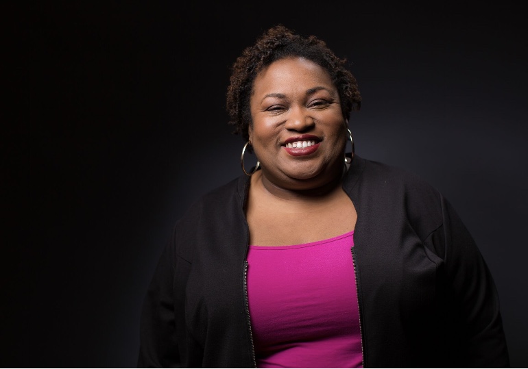 Brittney Cooper, author of Eloquent Rage, wearing a black jacket with a smile.