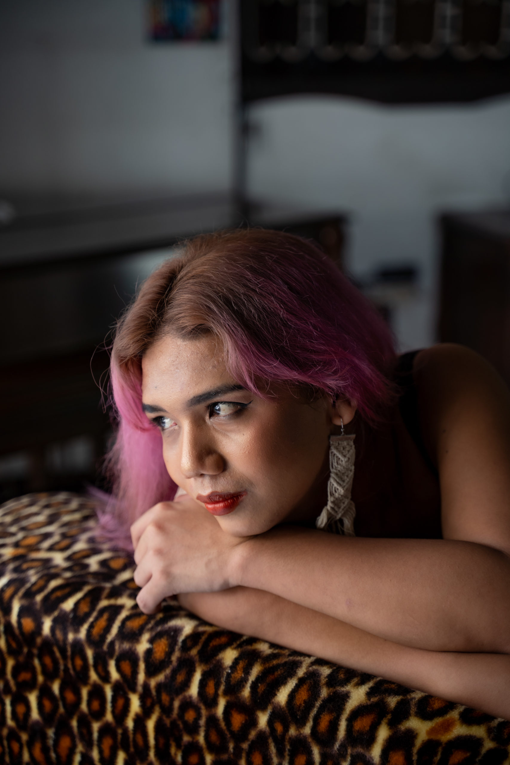 A photo of a woman seated in a char, looking out over her shoulder
