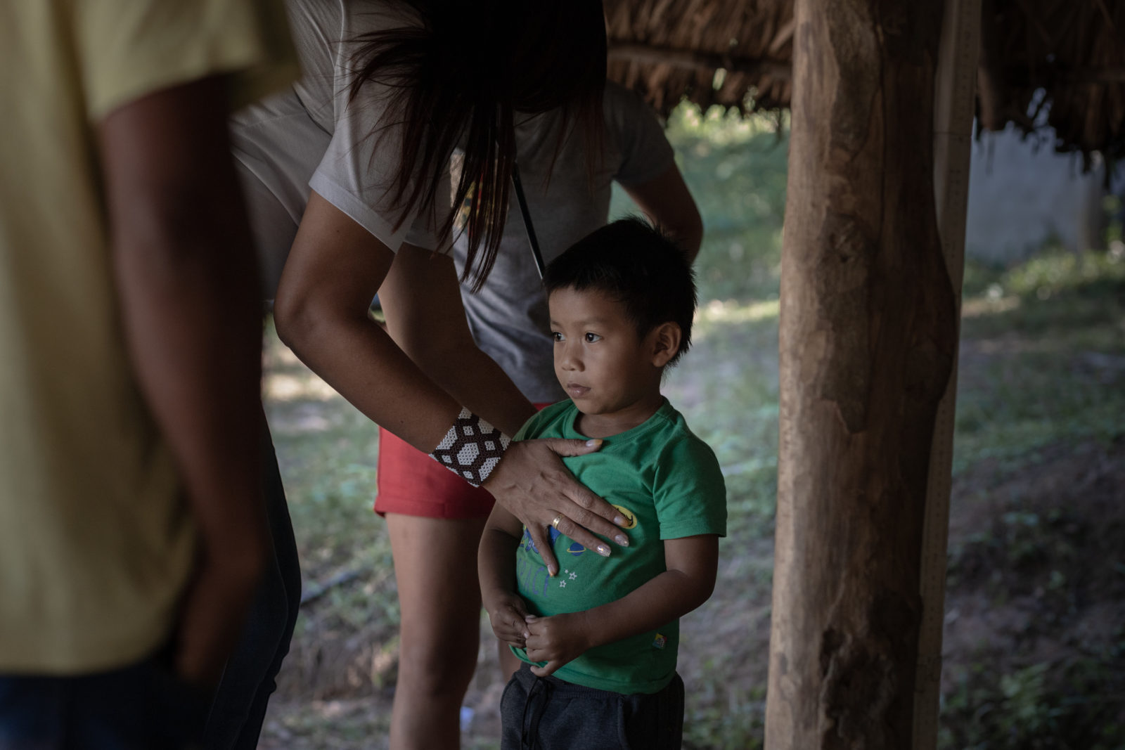 A photo of a doctor listening to the heart of a child