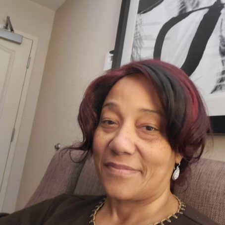 A photo portrait of a woman seated on a couch