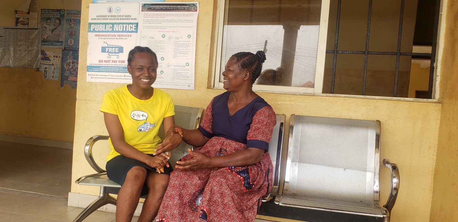 A photo of two women seated outside of a building