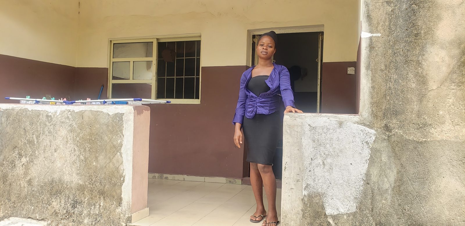 A photo of woman standing outside her home