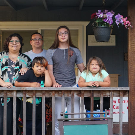 A photo of a family posing for a photo on a porch