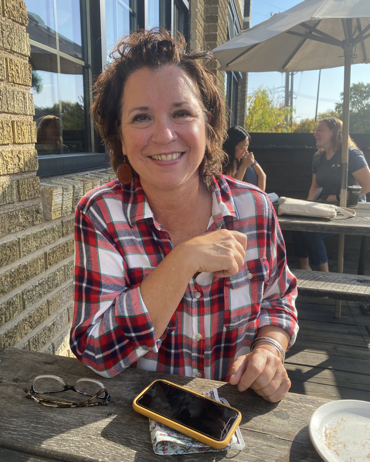 A photo of a woman seated outside at a table