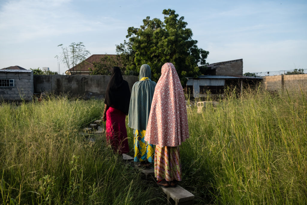 A photo of three women with their backs facing the camera