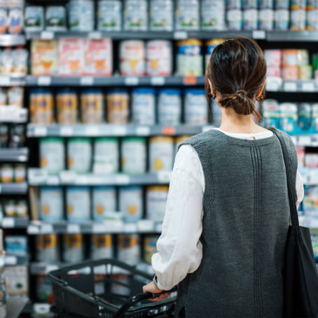 Photo of a person looking at items on a grocery store shelf