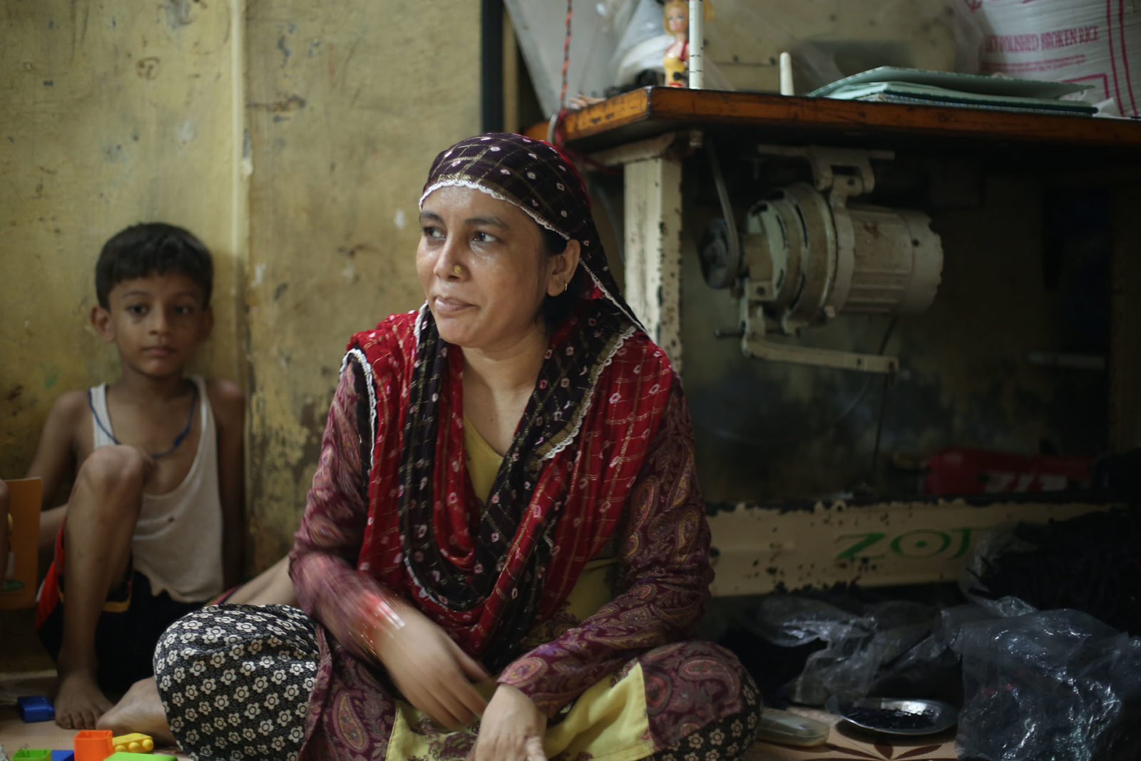 A photo of a woman with a little boy in the background