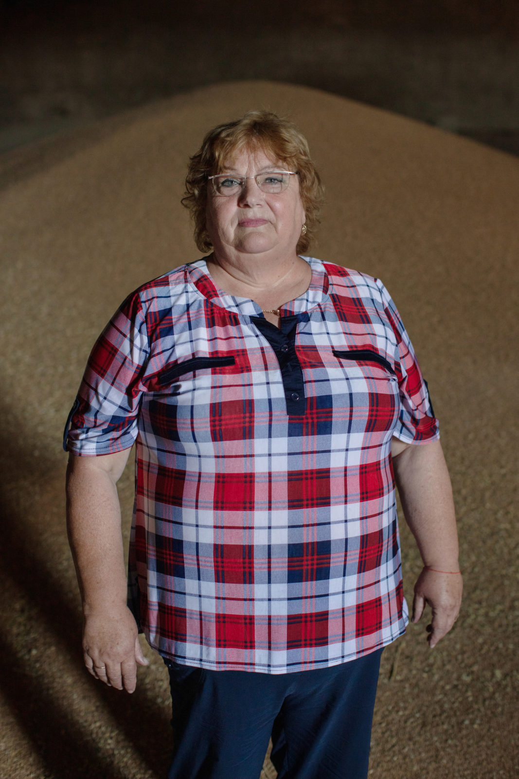 A woman standing in front of stored grain