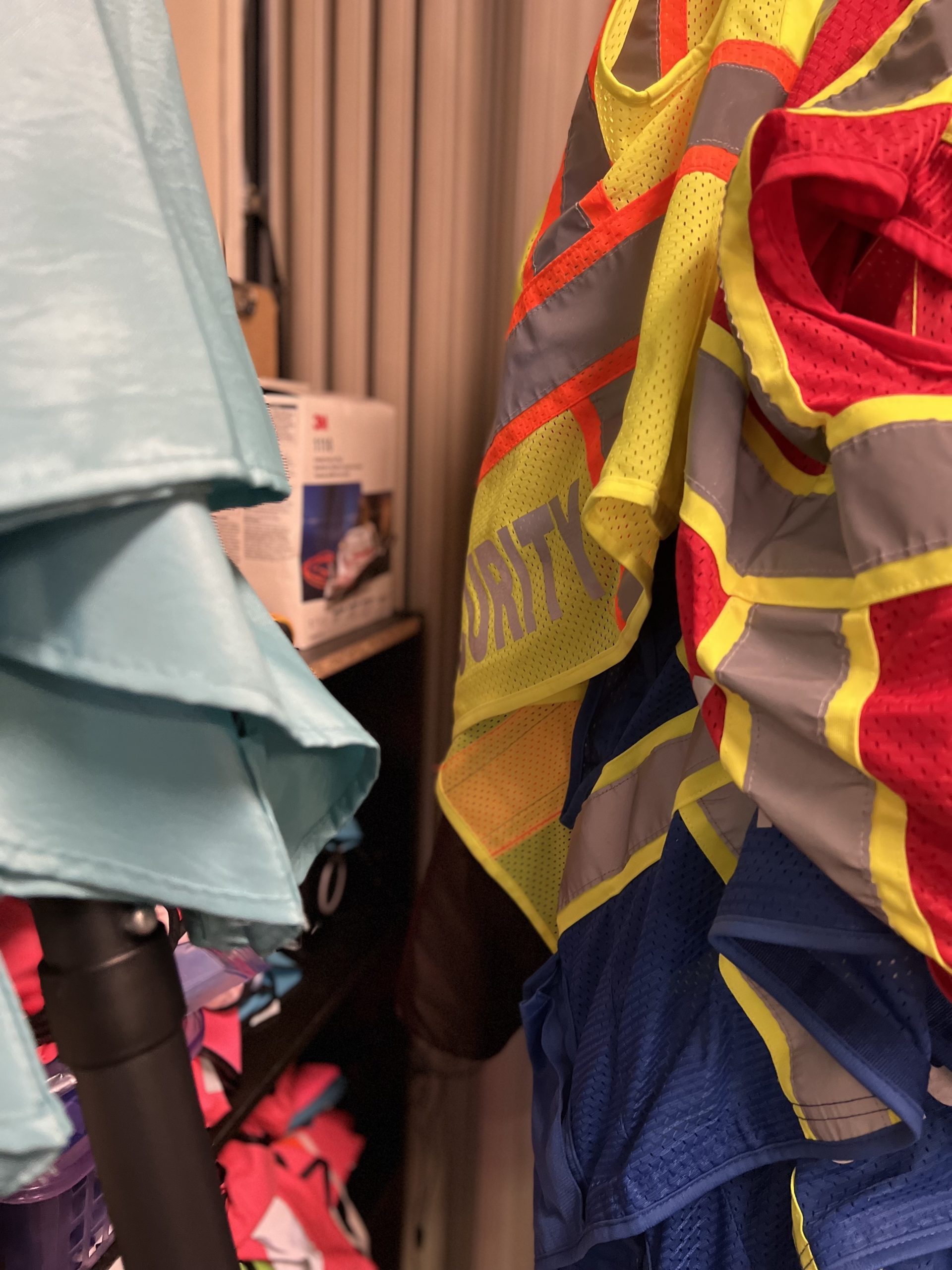 Clinic security and escort vests hang on a door.