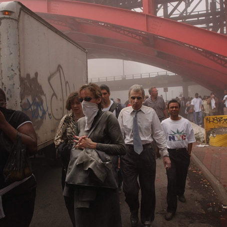 People cover their face from the smoke that came from the twin towers collapsing.