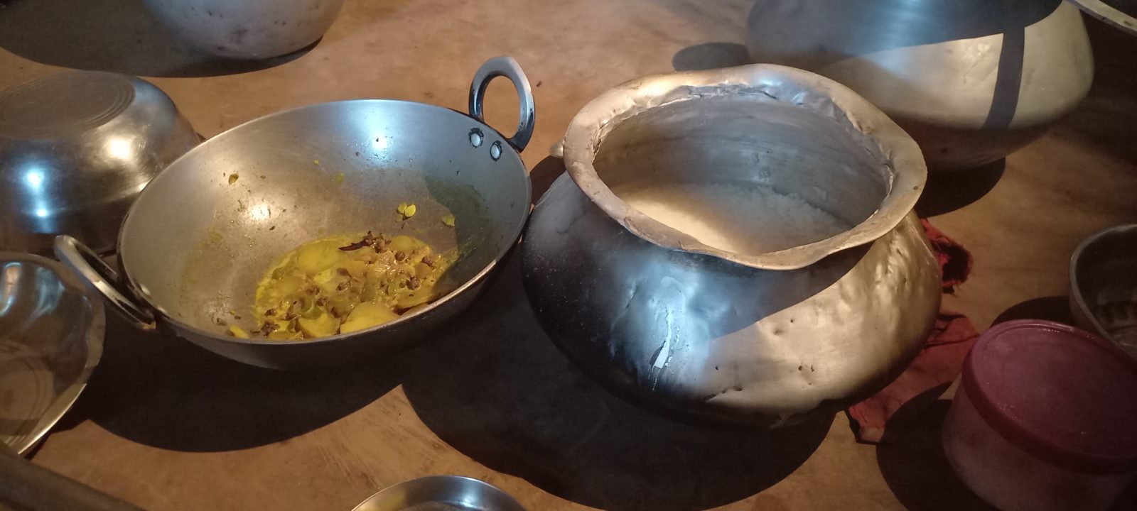 Food sits in two different pots on the floor.
