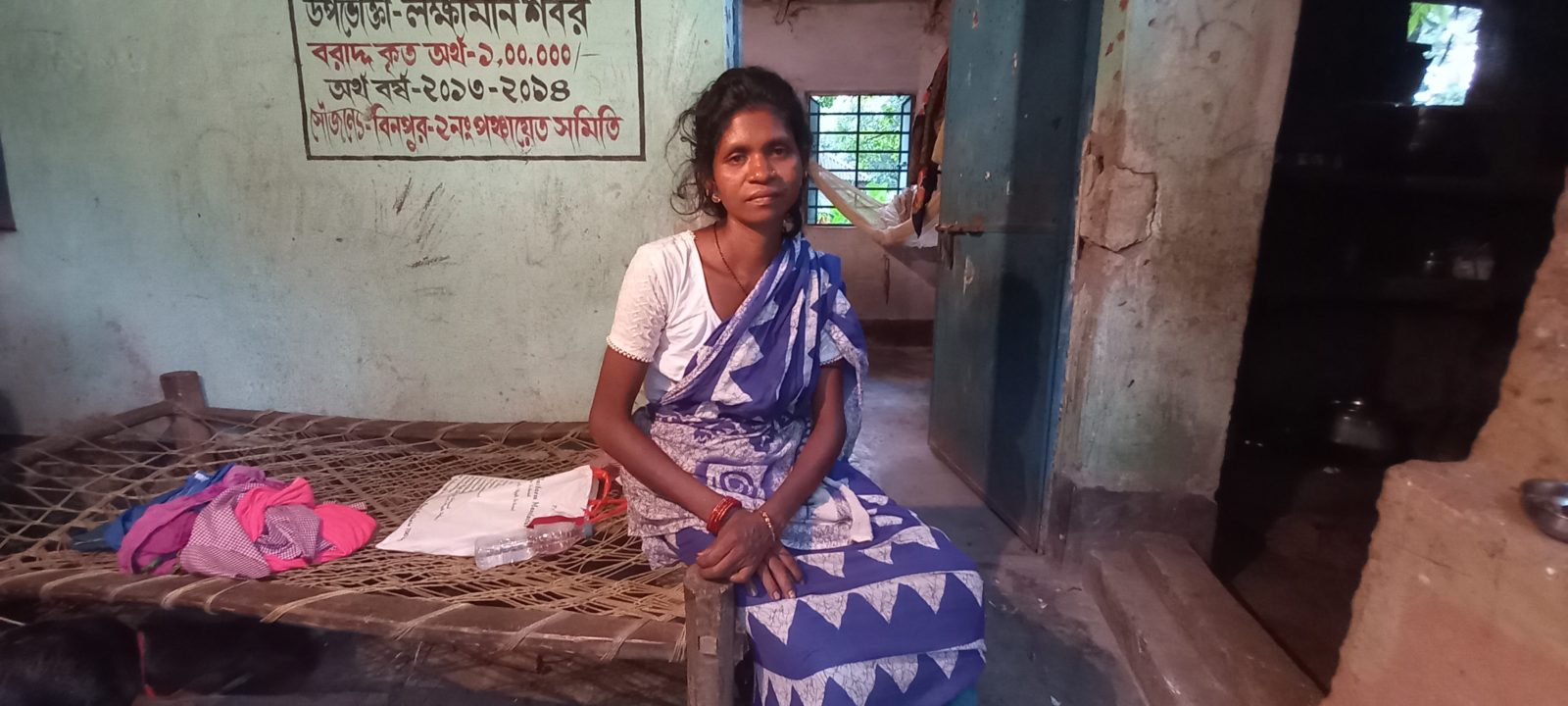 A woman sits on her bed.