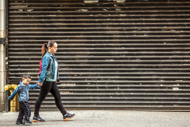 A woman walks with a child while holding his hand