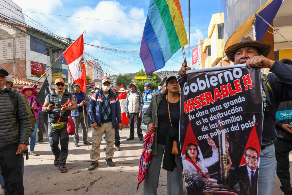 People stand in a street waving flag and shouting