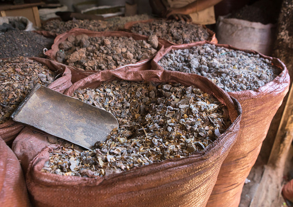 Piles of incense sit in brown bags at a market