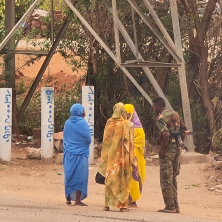 three women standing and talking to a soldier