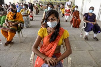 A group of people sitting outside, well spaced out