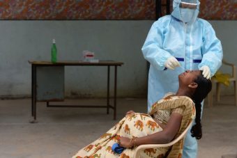 A health worker wearing collects a swab sample of a pregnant woman at a free COVID-19 testing center at Medchal Malkajgiri district on the outskirts of Hyderabad on August 24, 2020. (Photo by NOAH SEELAM/AFP via Getty Images)