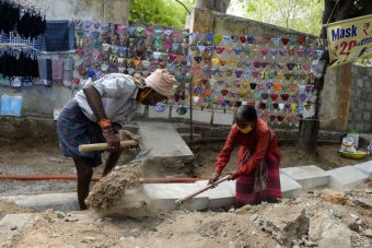 Laborers work at a road construction site amidst the coronavirus pandemic in Hyderabad, India on April 28, 2021.  (Photo by NOAH SEELAM/AFP via Getty Images)